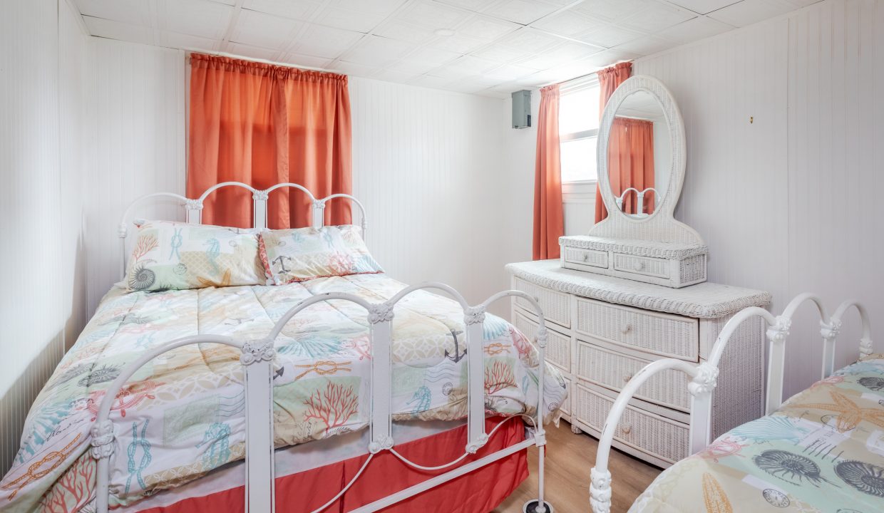 a bedroom with a bed, dresser and mirror.