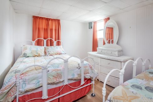 a bedroom with a bed, dresser and mirror.