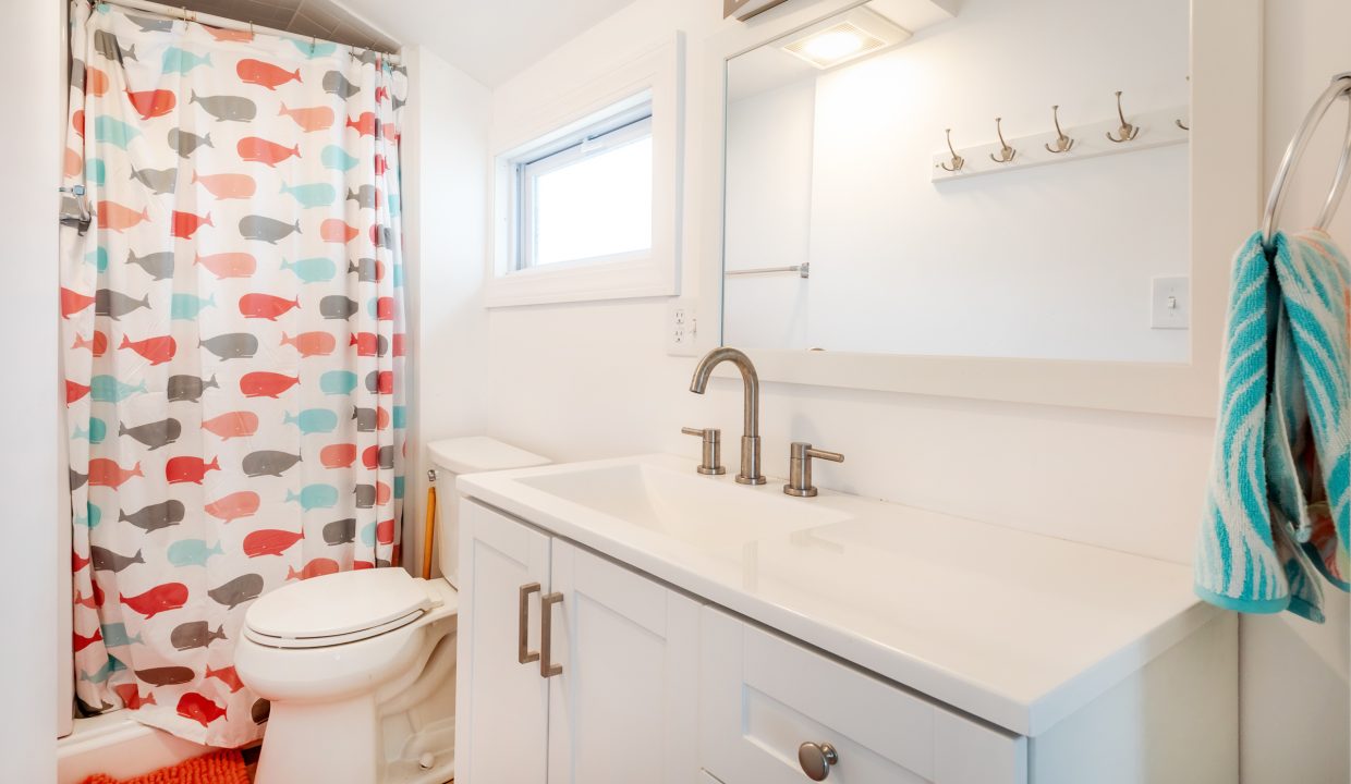 a bathroom with a sink, toilet, and shower curtain.