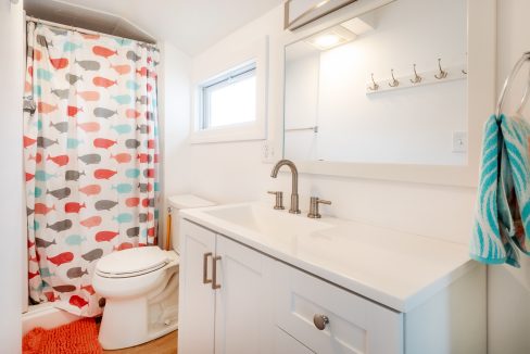 a bathroom with a sink, toilet, and shower curtain.