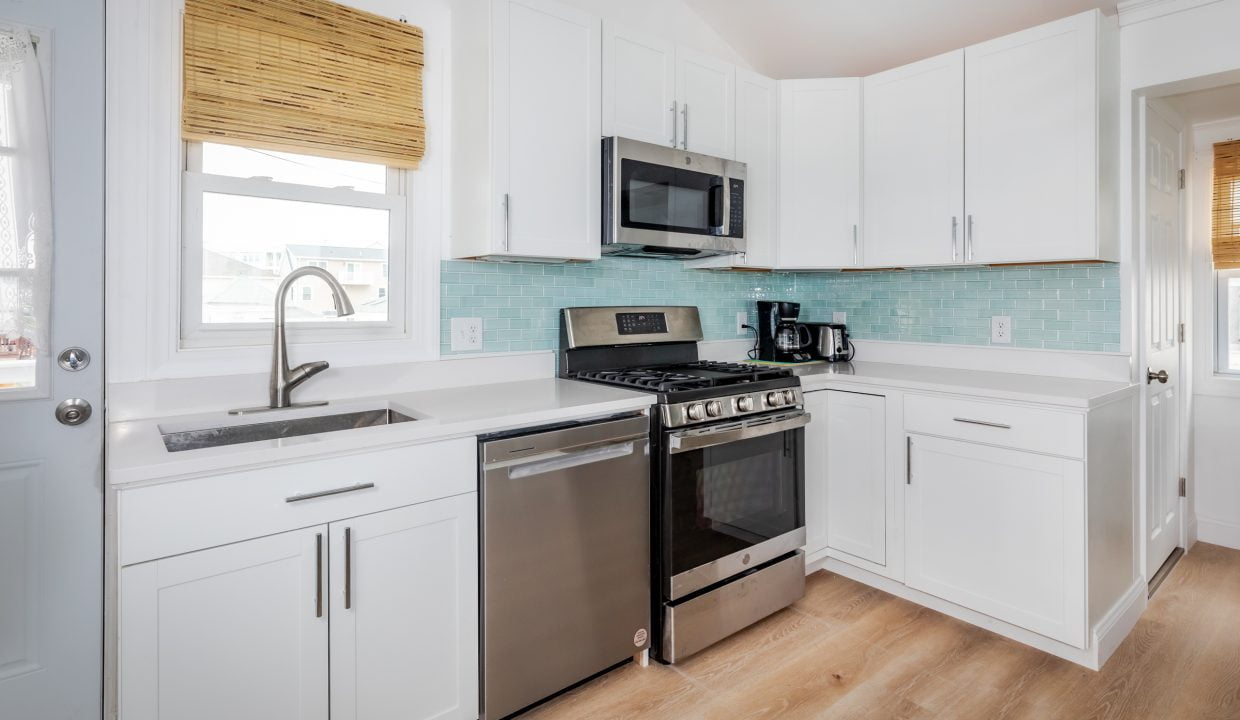 a kitchen with white cabinets and stainless steel appliances.