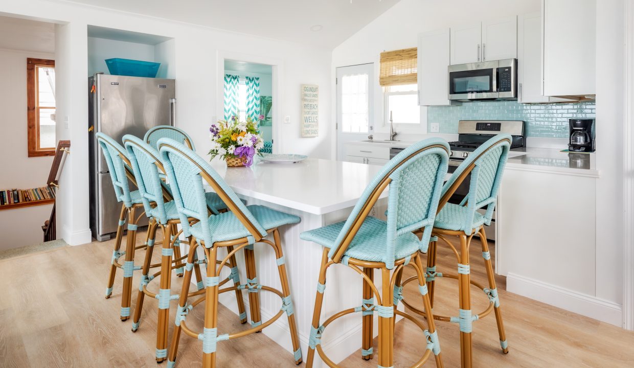 a kitchen with a center island and blue bar stools.