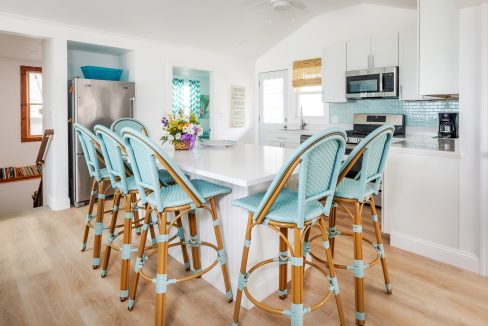 a kitchen with a center island and blue bar stools.