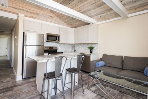 a living room with a couch a table and a refrigerator.