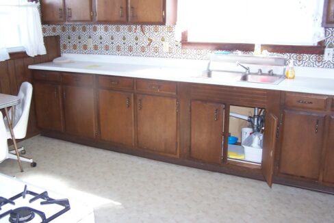 a kitchen with wooden cabinets and a stove top oven.