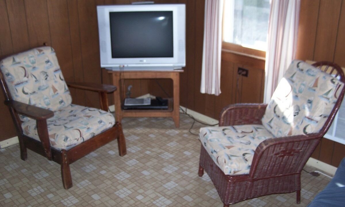 a living room with two chairs and a television.