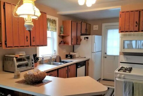 a kitchen with a sink, stove, microwave, and refrigerator.