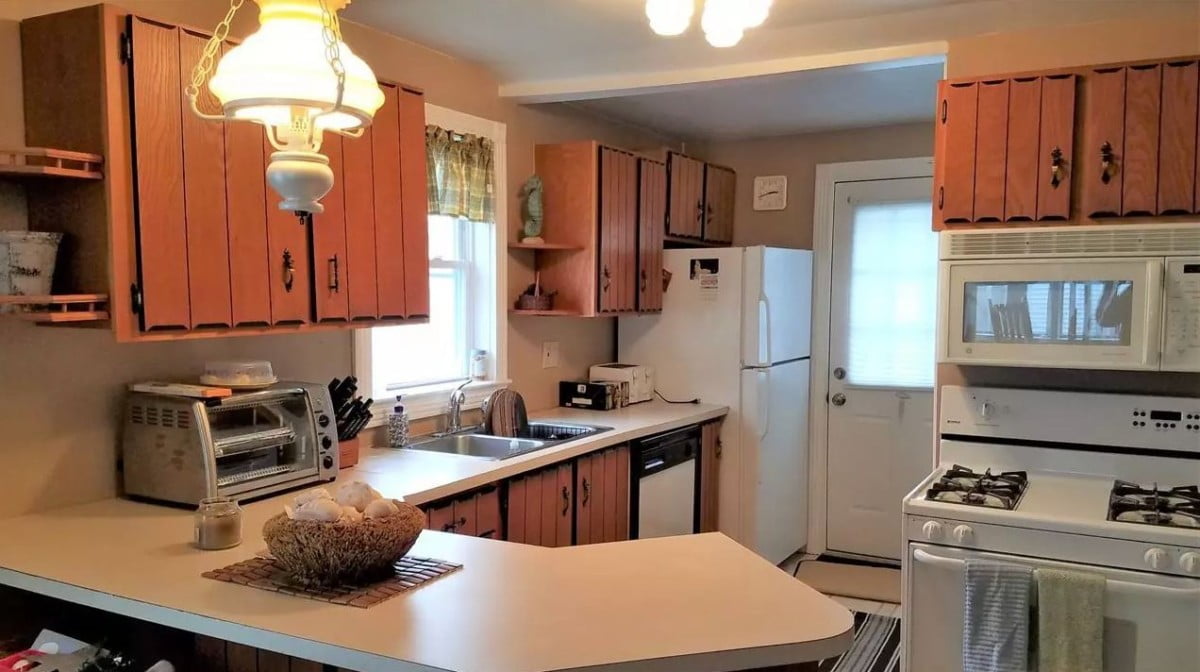 a kitchen with a sink, stove, microwave, and refrigerator.