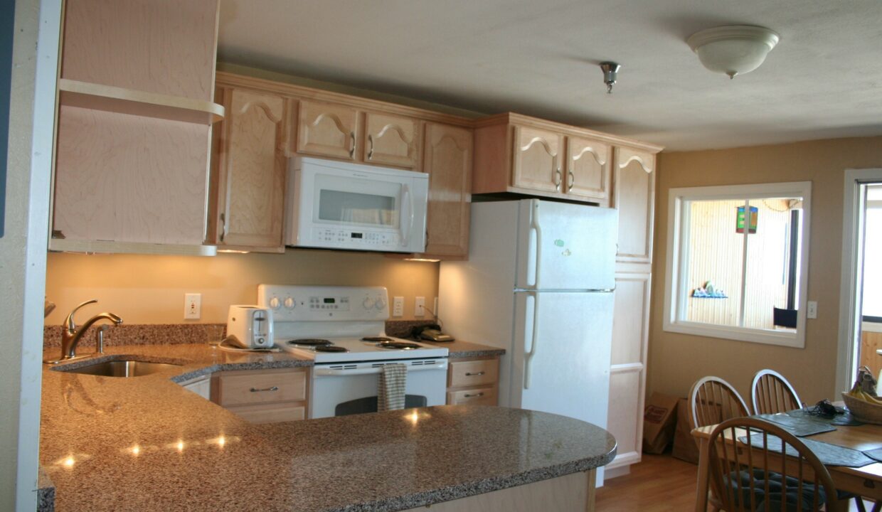 a kitchen with a refrigerator, stove, microwave and dining table.