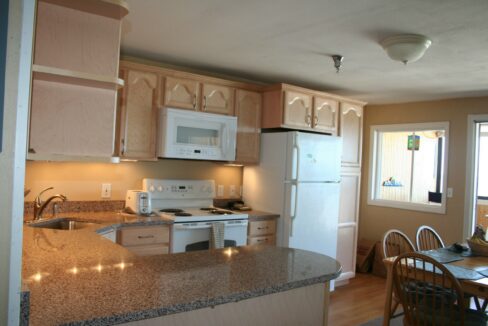 a kitchen with a refrigerator, stove, microwave and dining table.