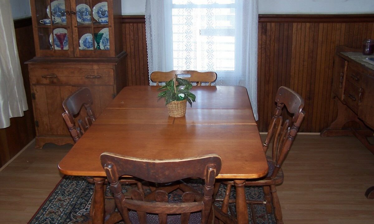 a dining room table with a vase of flowers on top of it.