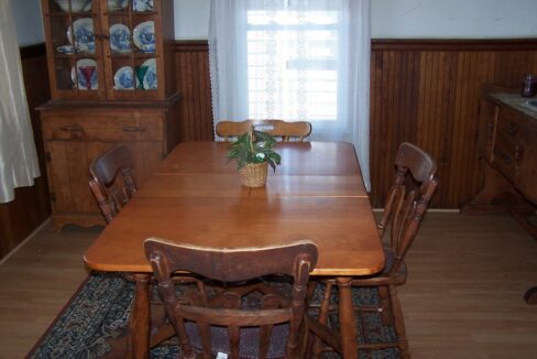 a dining room table with a vase of flowers on top of it.