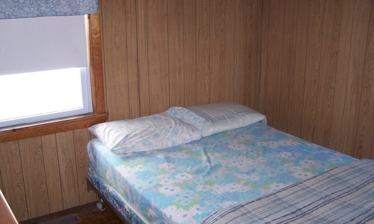 a bed in a room with a wooden wall.