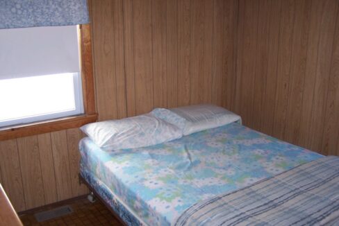 a bed in a room with a wooden wall.