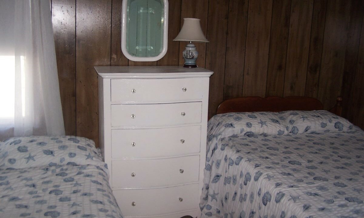 a bedroom with two beds and a dresser.