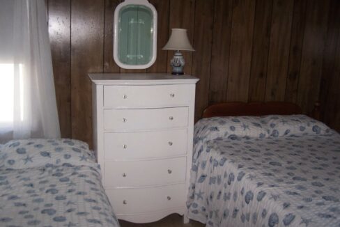 a bedroom with two beds and a dresser.