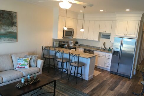 a living room with a couch a table and a refrigerator.