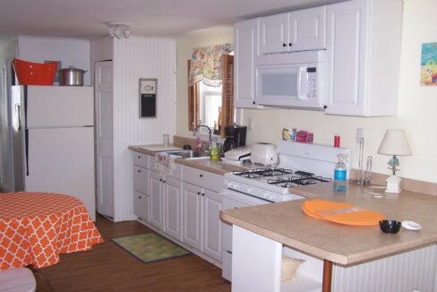 a kitchen with white cabinets and white appliances.