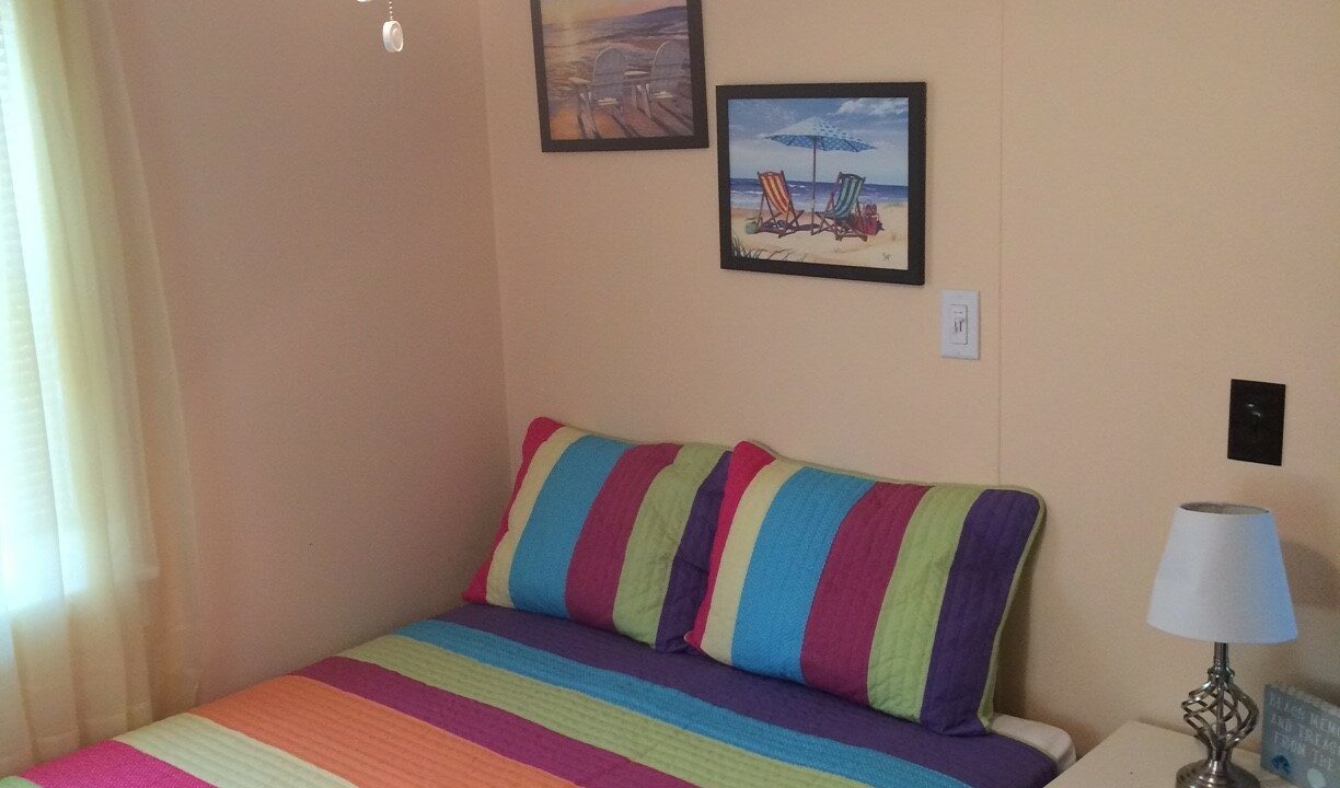 a bedroom with a bed and a colorful blanket.