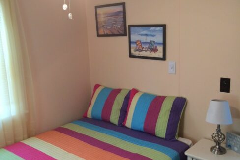 a bedroom with a bed and a colorful blanket.