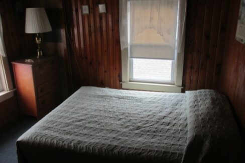 a bed sitting in a bedroom next to a window.