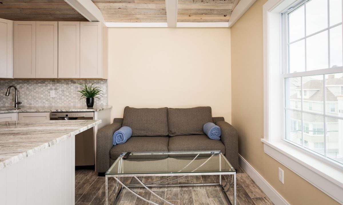 a living room with a couch a table and a window.