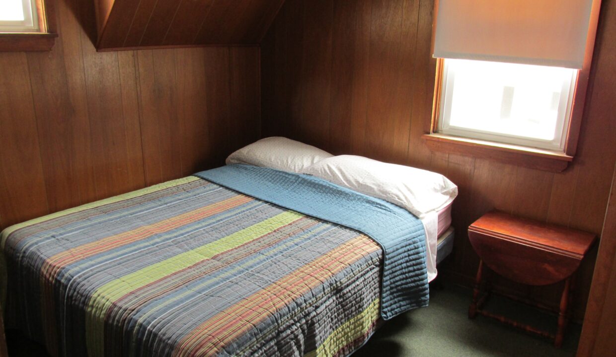 a bed sitting in a bedroom next to a window.