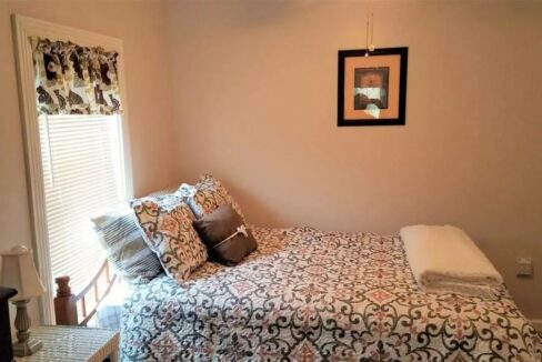 a bed sitting in a bedroom next to a window.