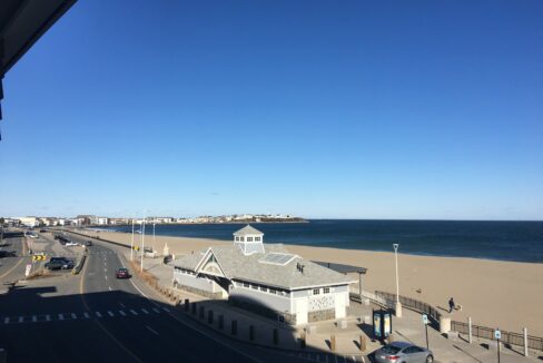 a view of a beach from a balcony of a building.