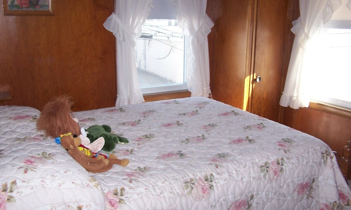 a teddy bear sitting on a bed in a bedroom.