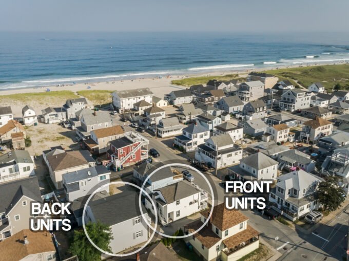 An aerial view of a house with a beach in the background.