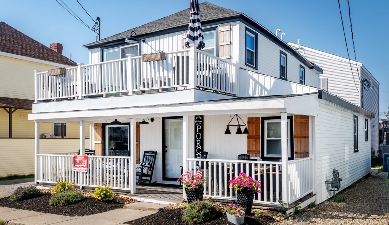 A white house with a balcony and a porch.