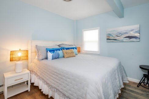 A bedroom with blue walls and a white bed.