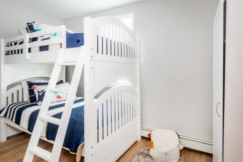 A white bunk bed with a ladder.