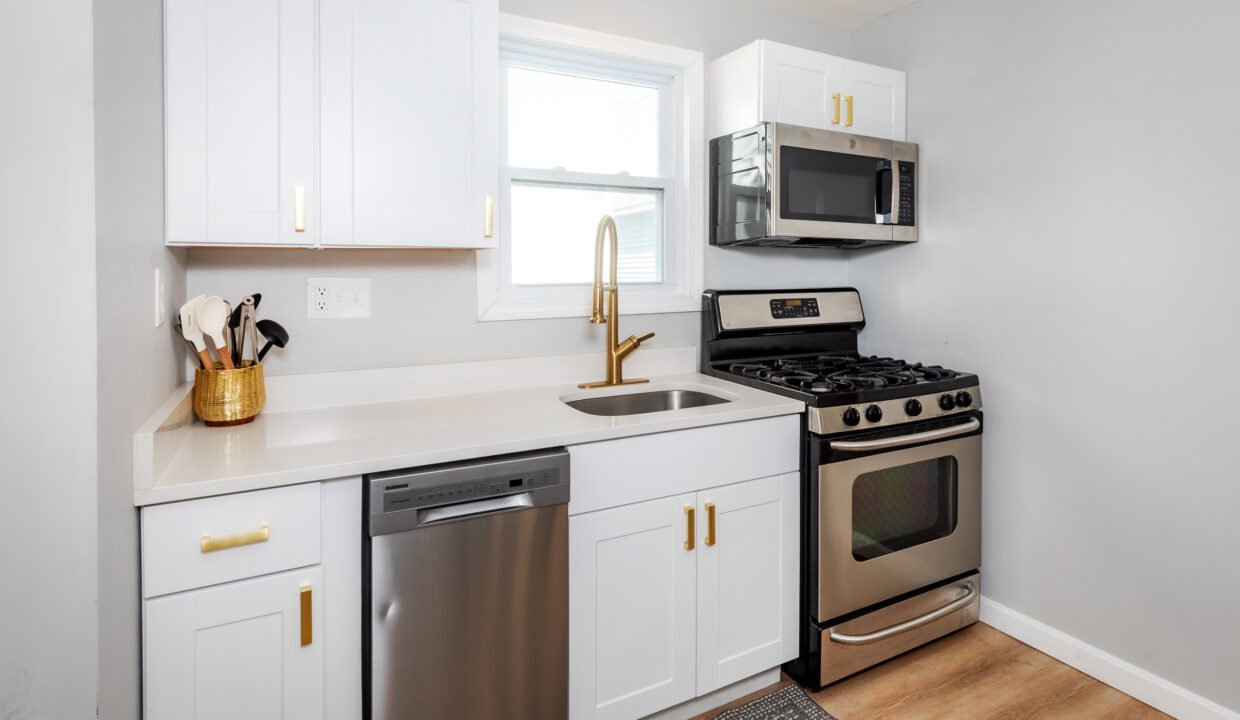 A small kitchen with white cabinets and stainless steel appliances.