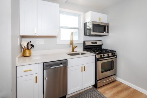 A small kitchen with white cabinets and stainless steel appliances.