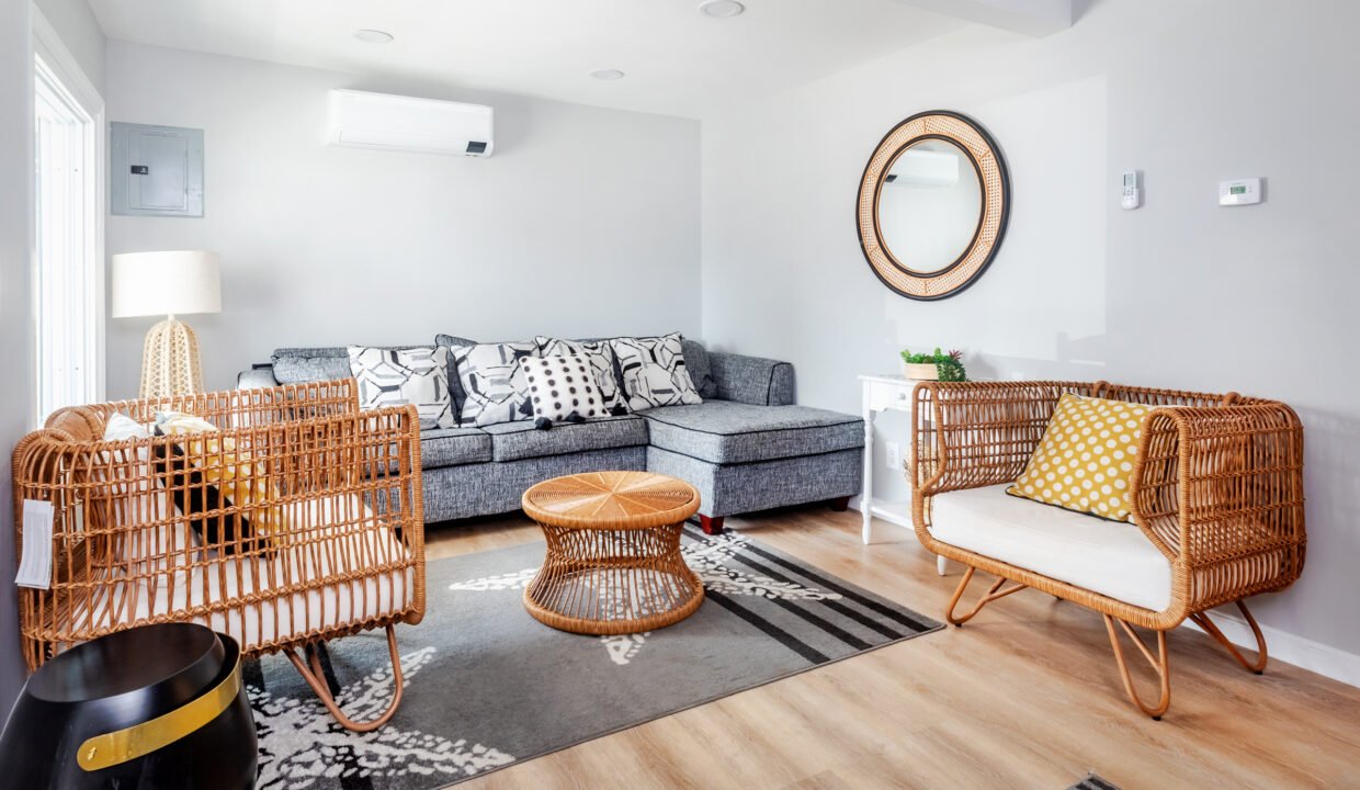 A living room with grey walls and wicker furniture.