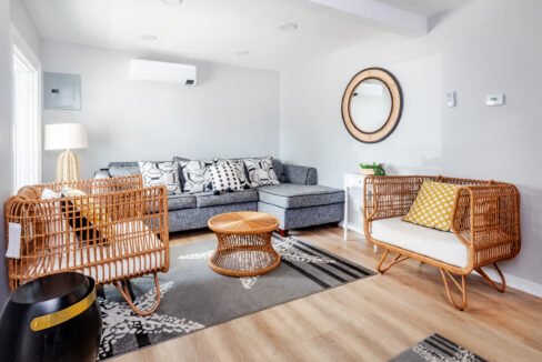 A living room with grey walls and wicker furniture.