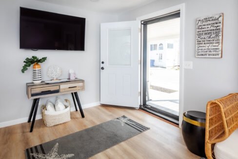 The entryway of a home with a tv and a rug.