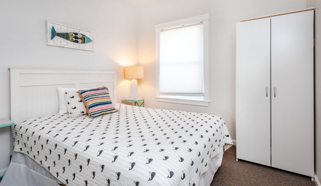 A bedroom with a bed and a dresser.