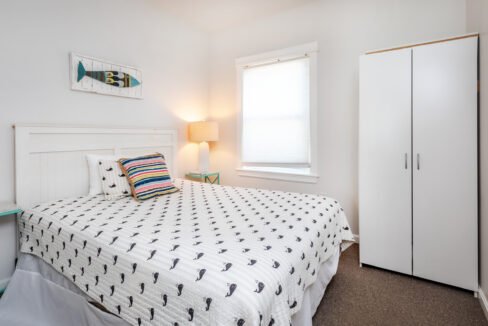 A bedroom with a bed and a dresser.