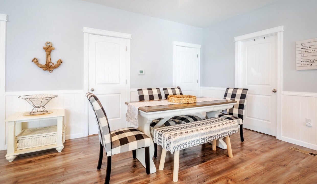 A dining room with a white table and chairs.