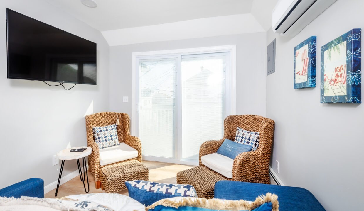 A living room with blue couches and a tv.