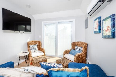 A living room with blue couches and a tv.