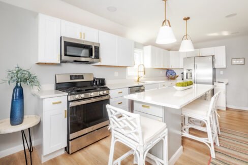 A kitchen with white cabinets and stainless steel appliances.