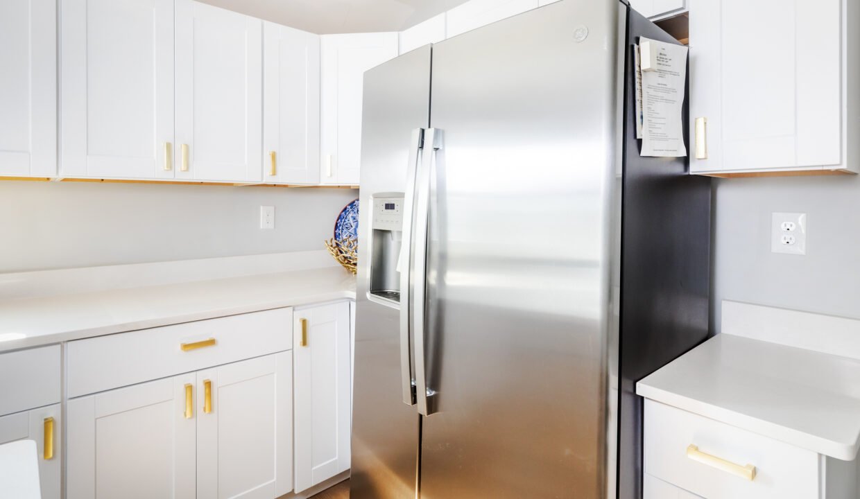 A stainless steel refrigerator in a white kitchen.