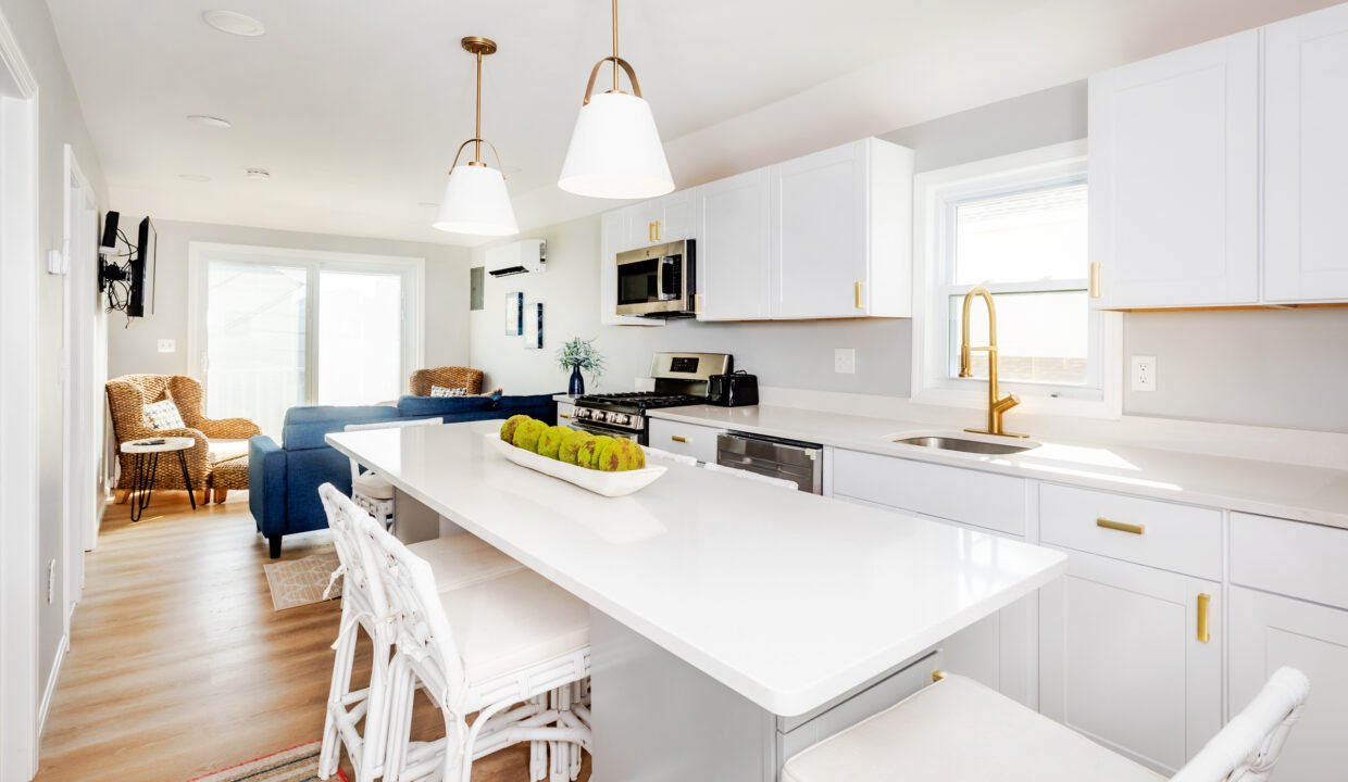 A kitchen with white cabinets and white counter tops.