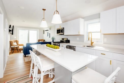 A kitchen with white cabinets and white counter tops.