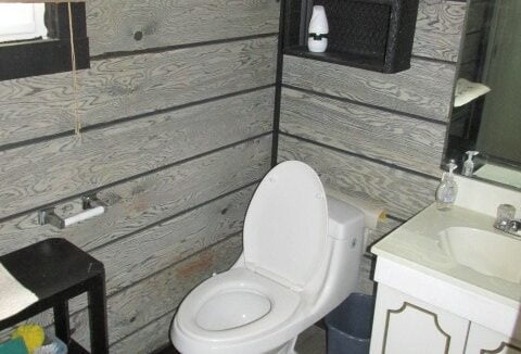 a white toilet sitting in a bathroom next to a sink.