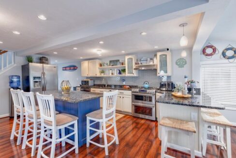 a large kitchen with a center island with chairs.